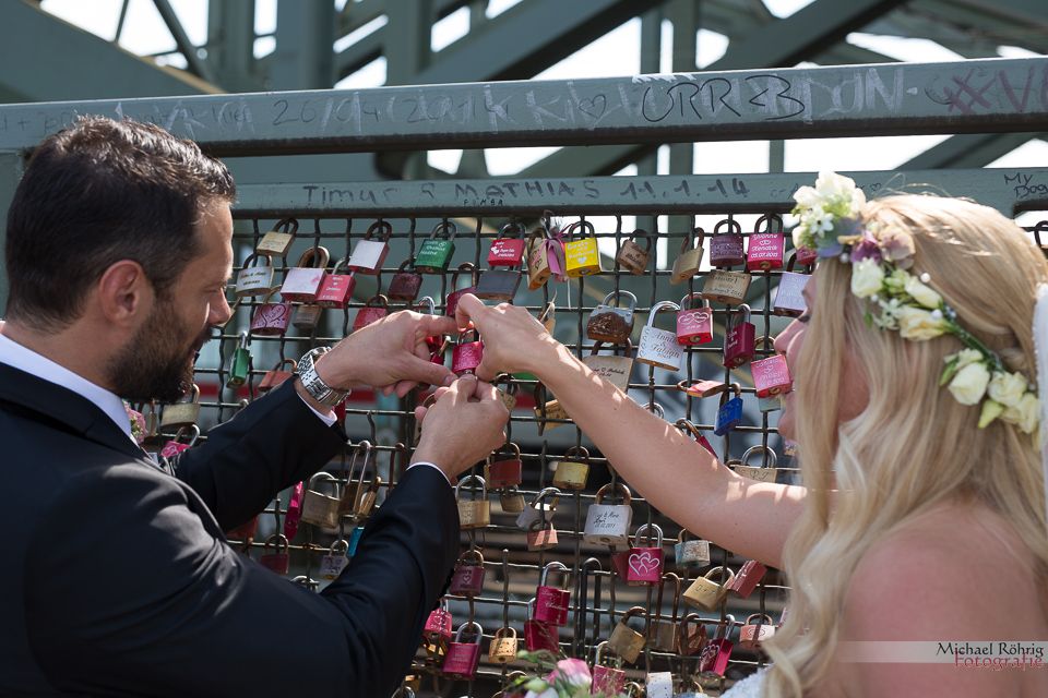 Michael Röhrig Hochzeitsfotograf - Brautpaar bringt Liebesschloss an der Hohenzollernbrücke an.